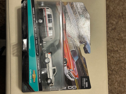 Original sealed diecast package front with Chevrolet pickup and camper
